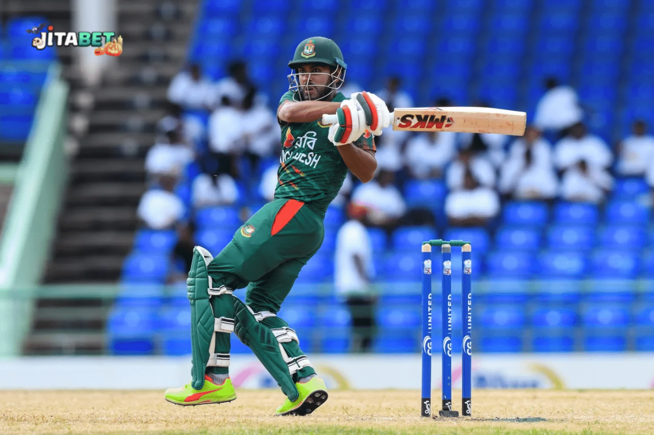 a man in green uniform swinging a bat